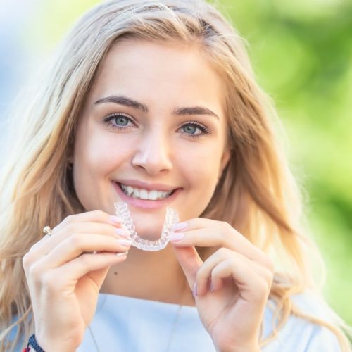 Invisalign,Orthodontics,Concept,-,Young,Attractive,Woman,Holding,-,Using