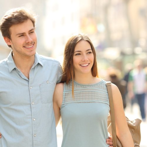 Couple,Of,Tourists,Taking,A,Walk,In,A,City,Street